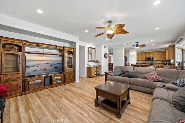 living room with light wood-style floors, ceiling fan, and recessed lighting