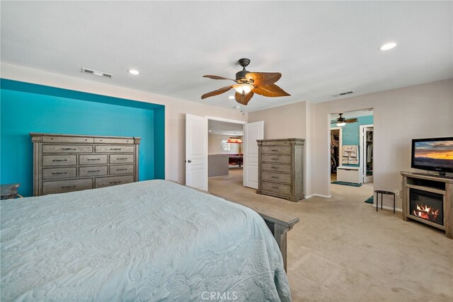 bedroom featuring light carpet, ceiling fan, visible vents, and recessed lighting