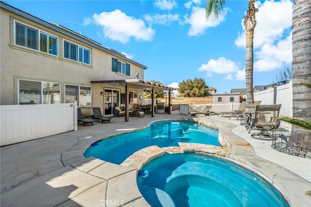 view of pool with an outdoor living space, a patio area, a pool with connected hot tub, and a fenced backyard