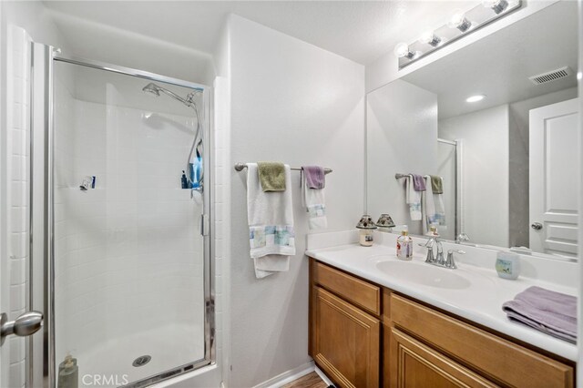 full bath with visible vents, a shower stall, and vanity