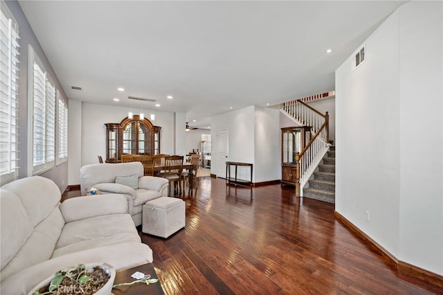 living area featuring wood-type flooring, stairs, visible vents, and baseboards