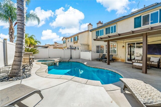 view of pool featuring a patio, a fenced backyard, and a pool with connected hot tub