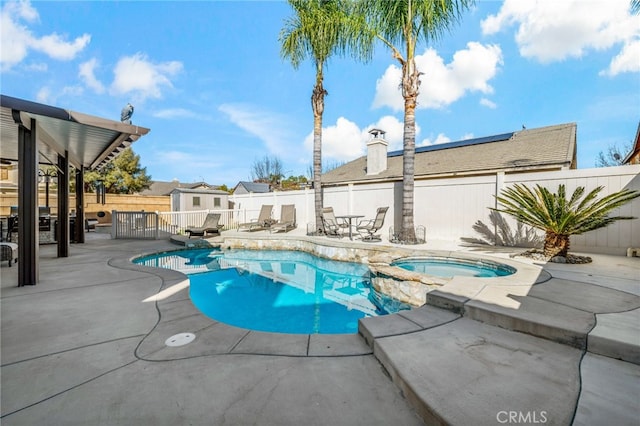 view of pool featuring a fenced backyard, a pool with connected hot tub, and a patio