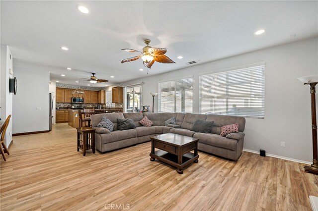 living area with light wood-style floors, recessed lighting, and baseboards