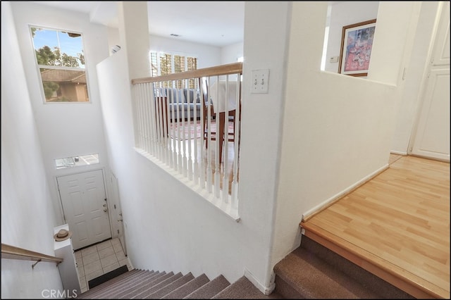 stairway featuring plenty of natural light and wood finished floors