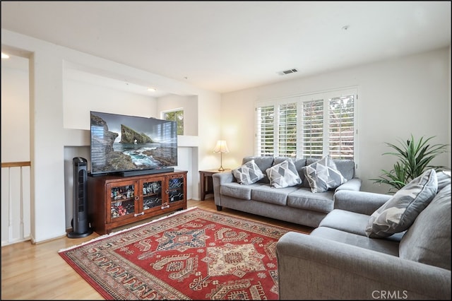 living room featuring visible vents and wood finished floors