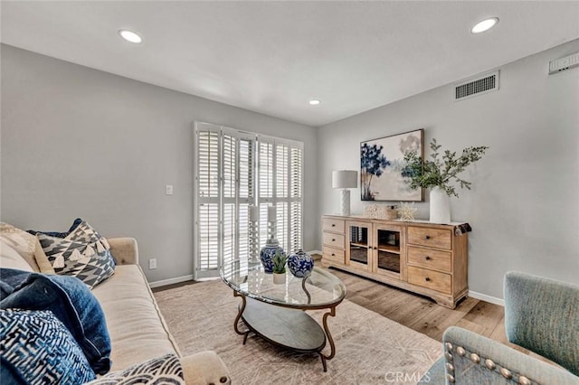 living area featuring recessed lighting, wood finished floors, visible vents, and baseboards