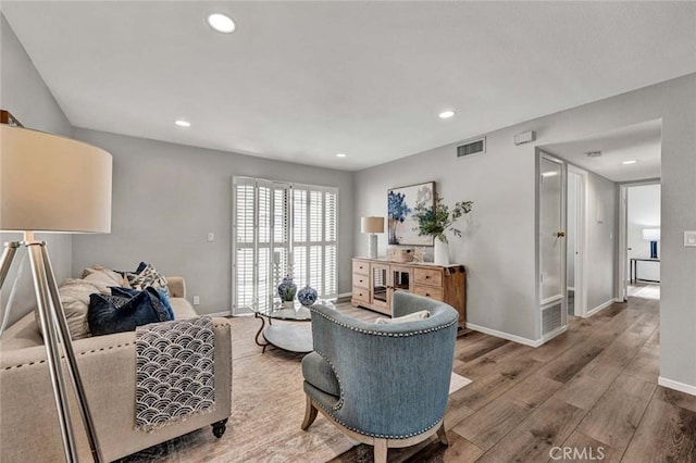 sitting room featuring baseboards, visible vents, wood finished floors, and recessed lighting