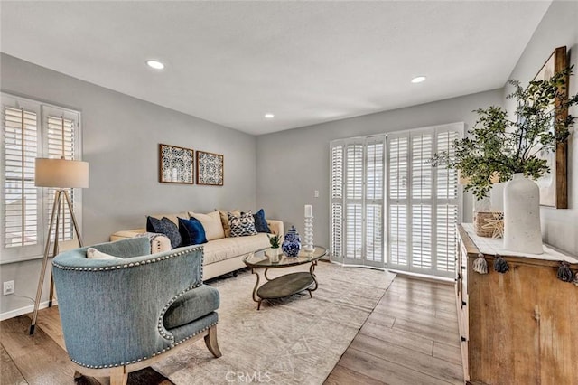 living area with recessed lighting, baseboards, and wood finished floors