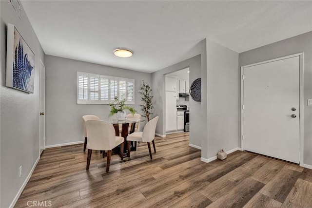 dining space featuring light wood-style flooring and baseboards