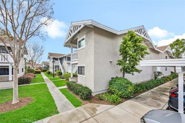 view of home's exterior with a residential view, a lawn, and stucco siding