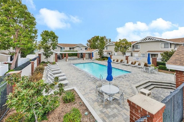 pool with a residential view, a patio area, and a fenced backyard