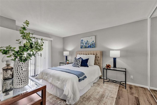 bedroom with access to outside, baseboards, and wood finished floors