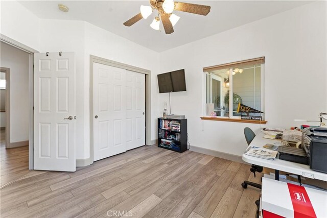 home office featuring ceiling fan, light wood-style flooring, and baseboards