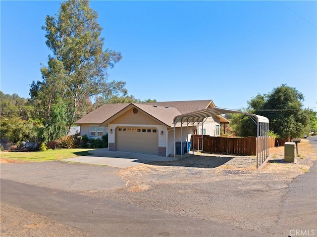 view of front facade featuring a garage, a detached carport, and driveway