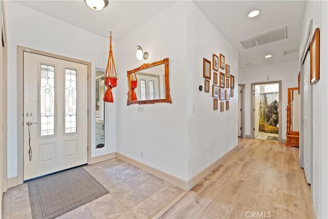 foyer featuring baseboards, visible vents, and recessed lighting