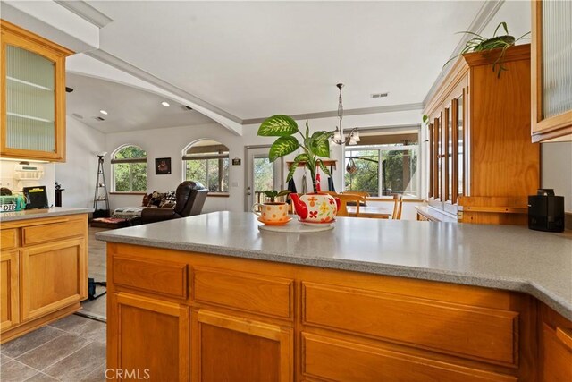 kitchen with visible vents, brown cabinetry, glass insert cabinets, open floor plan, and recessed lighting