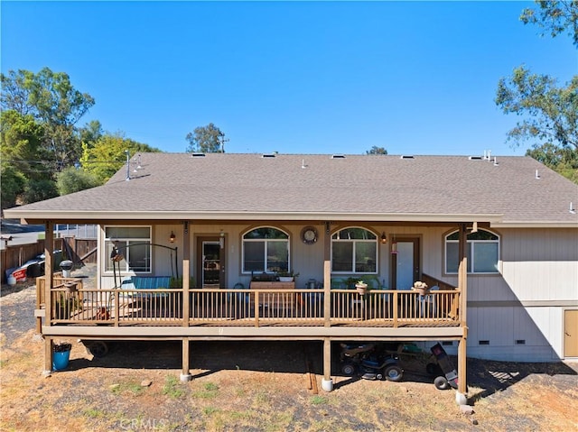 back of house featuring a shingled roof, crawl space, a porch, and fence