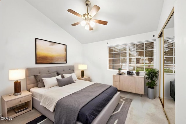 bedroom with light carpet, vaulted ceiling, and a ceiling fan