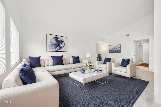 living area featuring high vaulted ceiling and visible vents