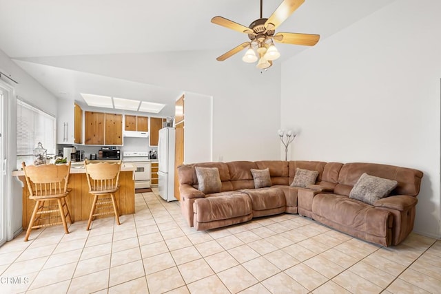 living area featuring ceiling fan, a toaster, vaulted ceiling, and light tile patterned floors