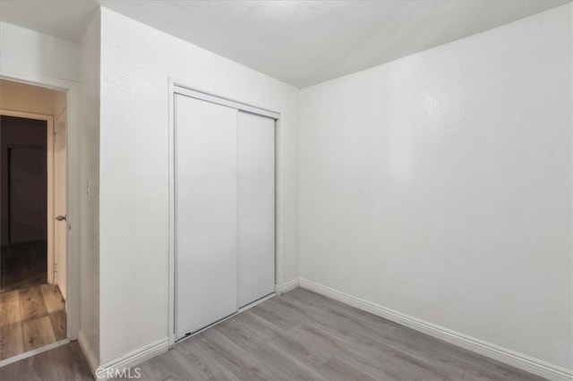 818 Record Ave, East Los Angeles, CA 90063 - unfurnished bedroom with light wood finished floors, a closet, and baseboards