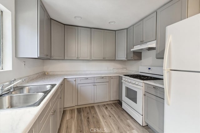 818 Record Ave, East Los Angeles, CA 90063 - kitchen with white appliances, under cabinet range hood, a sink, gray cabinetry, and light wood-type flooring