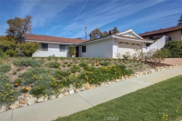 ranch-style house with a garage and stucco siding