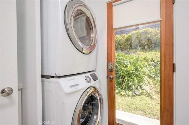 washroom featuring stacked washer and clothes dryer and laundry area