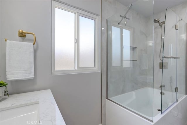 bathroom with a sink and shower / bath combination with glass door