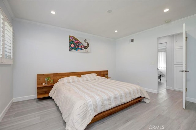 bedroom featuring visible vents, baseboards, light wood-style flooring, and crown molding