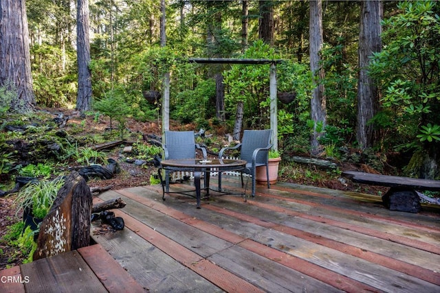 view of patio with a wooden deck and a forest view