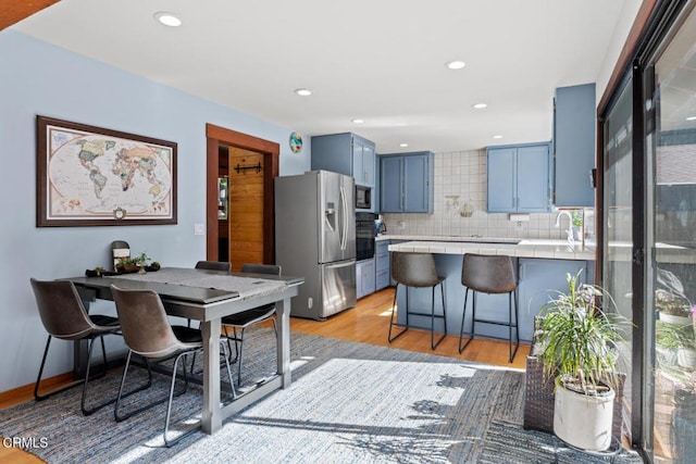 dining room featuring recessed lighting, baseboards, and light wood-style floors