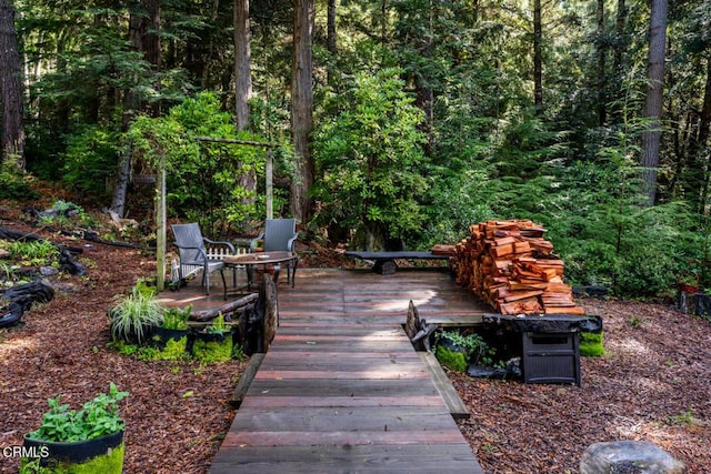 wooden terrace featuring a forest view