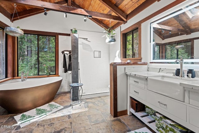 bathroom featuring vaulted ceiling with beams, stone tile floors, a tile shower, wooden ceiling, and vanity