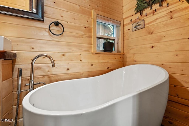 bathroom with a soaking tub and wood walls