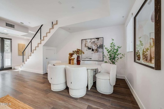 dining room with baseboards, stairs, visible vents, and wood finished floors