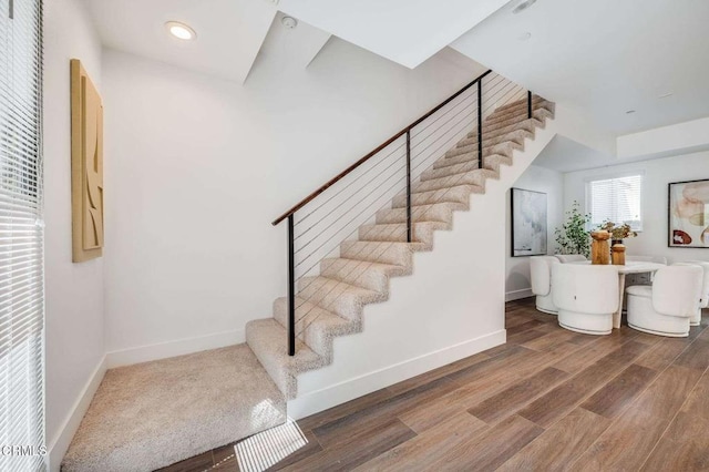 staircase with recessed lighting, wood finished floors, and baseboards