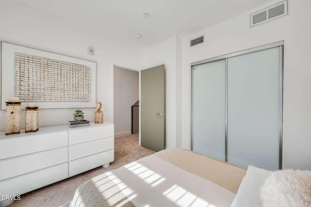 bedroom featuring visible vents, a closet, and light carpet