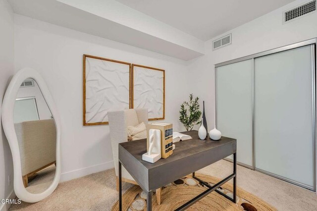 home office featuring visible vents, baseboards, and light carpet