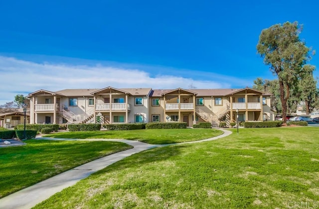 view of community with a yard, stairway, and a residential view