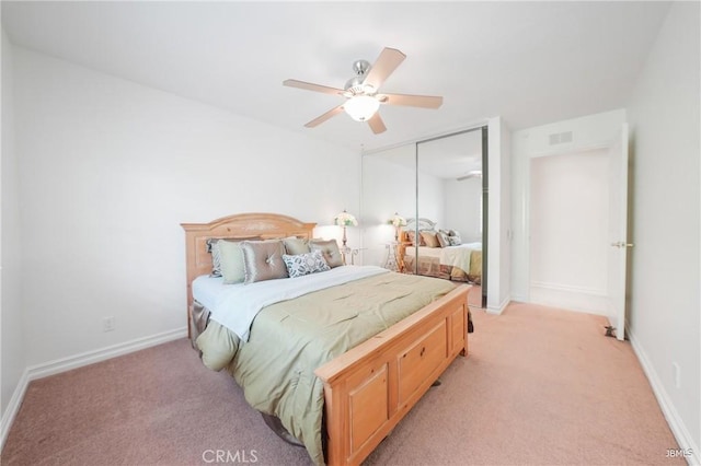 bedroom featuring baseboards, visible vents, a closet, and light colored carpet