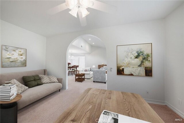 living room with carpet floors, arched walkways, ceiling fan, and baseboards