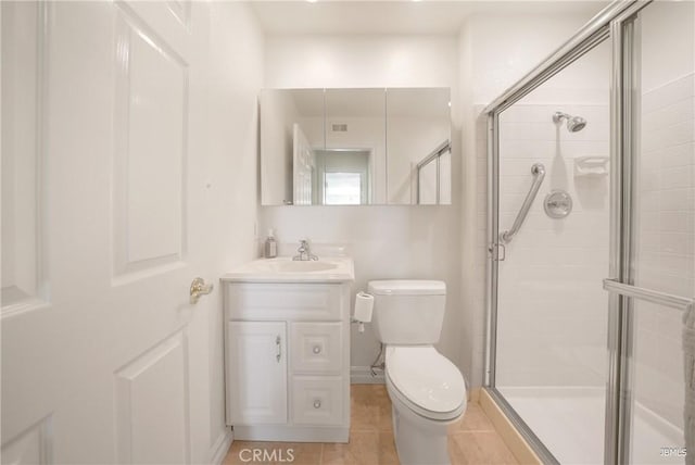 bathroom featuring a stall shower, tile patterned flooring, vanity, and toilet