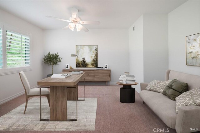 home office with light carpet, a ceiling fan, and baseboards