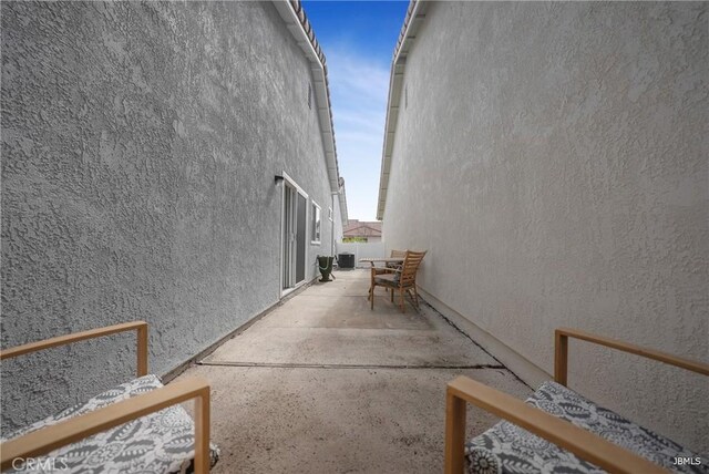 view of property exterior featuring a patio, central AC unit, and stucco siding