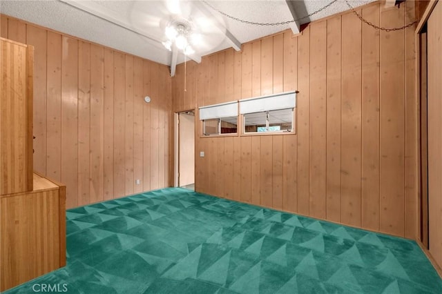 unfurnished room featuring wood walls and carpet flooring