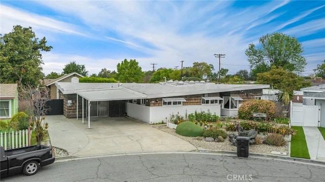 view of front of home featuring a carport, a gate, fence, and concrete driveway