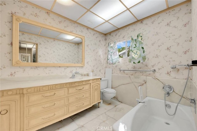 bathroom featuring toilet, vanity, marble finish floor, a bath, and wallpapered walls