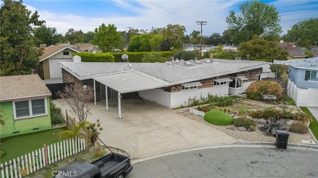 view of front of house with a carport, a residential view, fence, and driveway